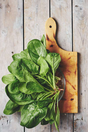 Green spinach leaves on a wooden surface, top view.の写真素材