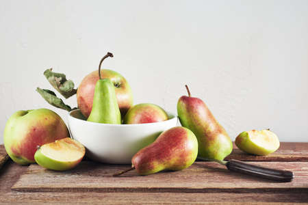 Ripe organic apples and pears on a wooden table, still life.