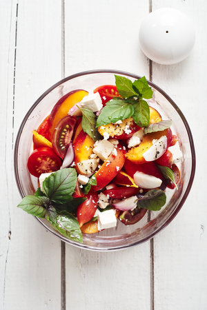 Salad with tomatoes, peach, red onion, feta cheese and basil. Top view.の写真素材