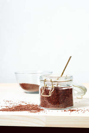 Raw red grain quinoa in a glass jar.