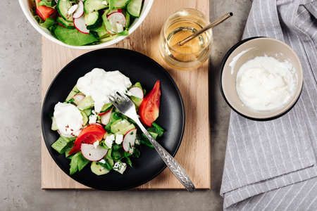 Vegetable salad with tomatoes, cucumber, radish, avocado and cheese.の写真素材
