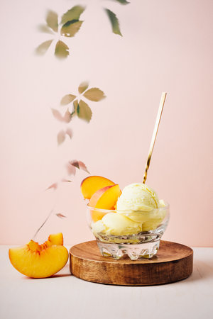 Glass of peach ice cream with a spoon.の写真素材