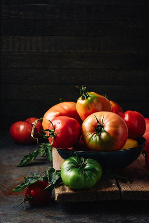 Freshly picked ripe red organic tomatoes on a dark background.の写真素材