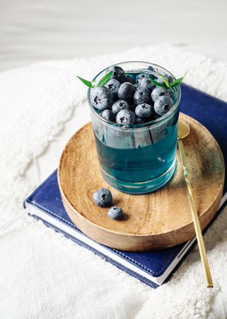 Blueberry gelatin dessert in a glass on a wooden tray.の写真素材