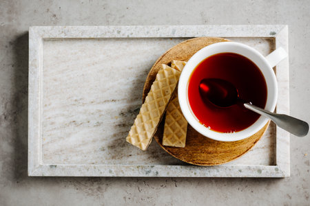 Cup of tea with waffles in a tray on a stone background.の写真素材
