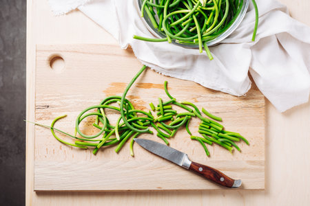 Chopped green garlic scapes on a cutting board.