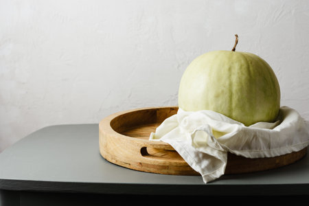 Ripe white watermelon on a wooden tray.