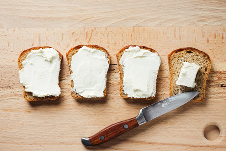 Cream cheese toasts on wooden table, top view.