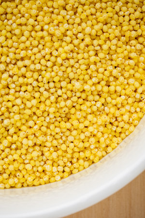 Organic raw hulled millet groats in a bowl close-up