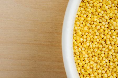 Organic raw hulled millet groats in a bowl close-upの写真素材