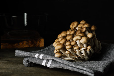 Fresh brown shimeji mushrooms on dark background.