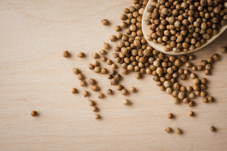 Coriander seeds in wooden spoon, close-up.の写真素材