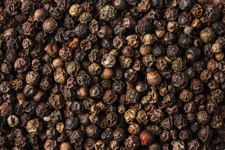 Whole black peppercorns close-up, texture, background.