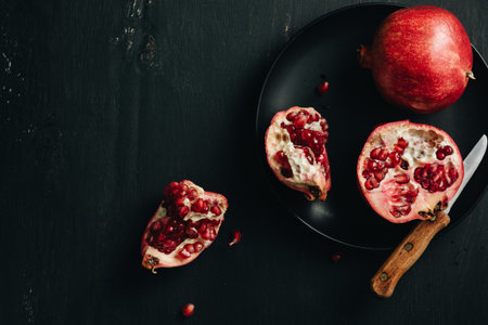 Fresh cut pomegranates on a dark background.の写真素材