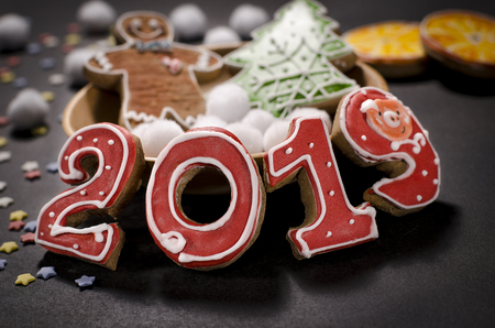 Christmas card on dark background gingerbread red numbers 2019 with slices of orange, multi-colored stars and gingerbread Manの写真素材