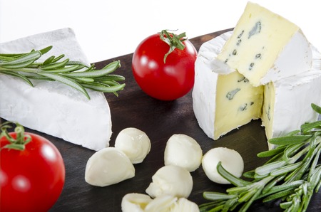 Tasting cheese dish with tomatos on old black dask. Food for wine and romantic, cheese delicatessen. Menu design horizontal. Top view.の写真素材