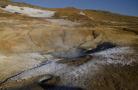 Iceland is a land of ice and fire. In the geothermal area Kerlingarfjoll one can see smoke and boiling fumaroles from the geothermal field as well as mountains covered by ice and snow.の写真素材