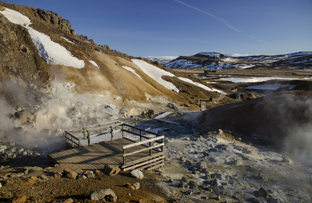 Iceland is a land of ice and fire. In the geothermal area Kerlingarfjoll one can see smoke and boiling fumaroles from the geothermal field as well as mountains covered by ice and snow.の写真素材