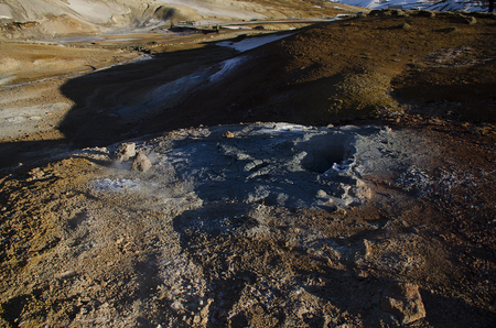 Fumarole fields of Iceland covered with yellow brimstone with boiling mud craters against the winter skyの写真素材