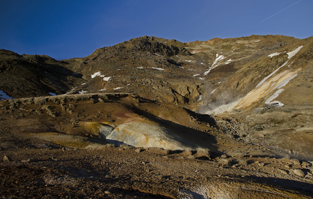Fumarole fields of Iceland covered with yellow brimstone with boiling mud craters against the winter skyの写真素材