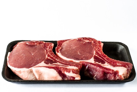Top view of black foam food tray with Raw marbled meat steak isolated on whiteの写真素材