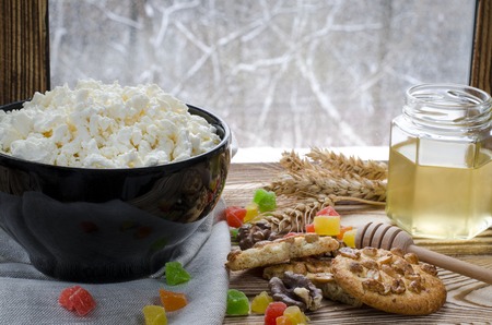 A healthy breakfast. cottage cheese are at the black plate on the wood backgroundの写真素材