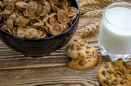 A healthy breakfast. Cereals are at the black plate on the wood backgroundの写真素材