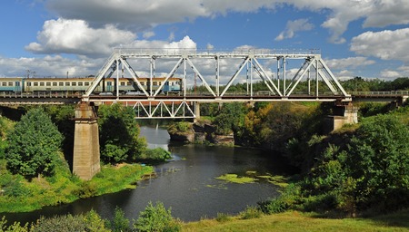Railway bridge over the beautiful river, on which the train goesの写真素材