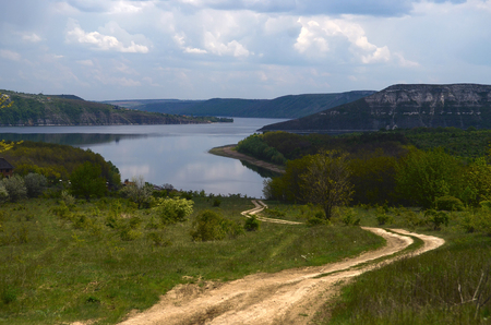 Huge sheer stone cliffs on the background of a river Dniester and a blue sky with clouds. Ukraineの写真素材