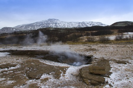 Litli geyser eruption in the South-western part of Iceland, in the geothermal area beside the Hvitau River amid the dark winter skyの写真素材