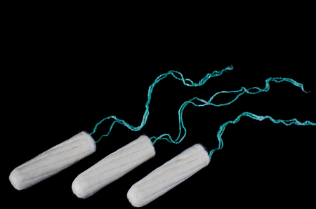 Menstrual period concept. Woman hygiene protection. Cotton tampons on black background. Top view,...