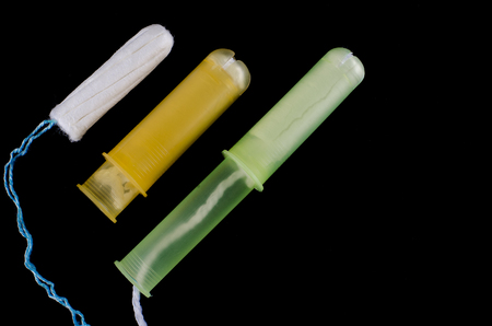 Menstrual period concept. Woman hygiene protection. Cotton tampons on black background. Top view,...