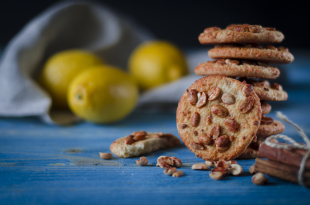 Round orange biscuits with colorful candied fruits and a slice of juicy orange lying on a wooden table. Closeupの写真素材