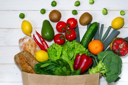 Paper bag of different health food on white wooden background. Top viewの写真素材