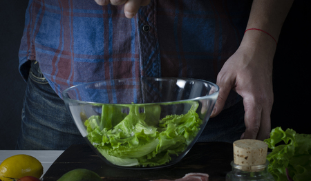 Man cooking green detox salad of romaine lettuce. Healthy food conceptの写真素材