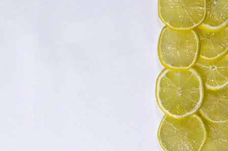 Thinly sliced lemon wedges lie on a white background with copy space top viewの写真素材