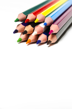 Colourful sharp pencils lie on a white background with copy space top viewの写真素材