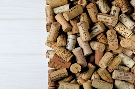 Used wine corks on sackcloth background with empty space for text. Colorful corks from white and red wine bottlesの写真素材