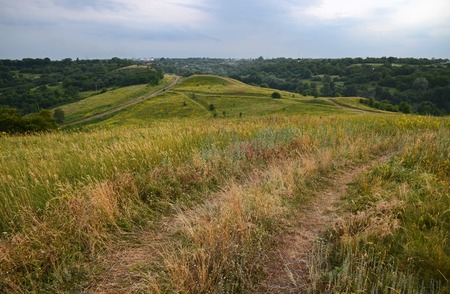 Summer landscape with unpaved roads among high green hills. Ukraineの写真素材