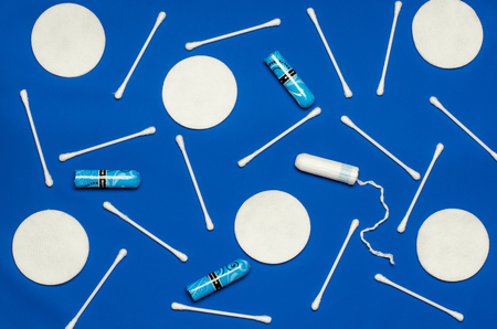 Hygiene products: round white cotton pads and cotton swabs are on colored background. Top view, flat layの写真素材