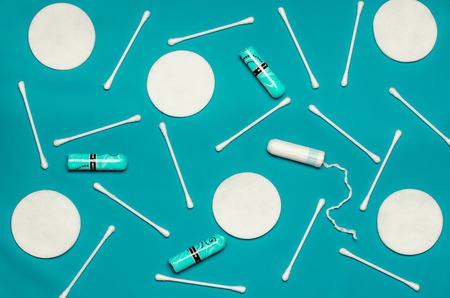 Hygiene products: round white cotton pads and cotton swabs are on colored background. Top view, flat layの写真素材