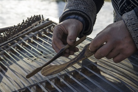 Hands dirty old street musician played on an old musical instrument. Ukraineの写真素材