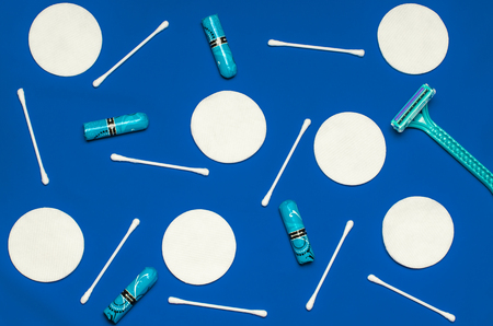 Hygiene products: round white cotton pads and cotton swabs are on colored background. Top view, flat layの写真素材