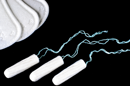 Menstrual period concept. Woman hygiene protection. Cotton tampons on black background. Top view, flat layの写真素材