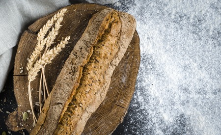 Freshly baked homemade traditional bread on rustic wooden table, top view