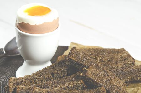 Healthy food. English breakfast with boiled egg and croutons on a white wood background. Healthy...