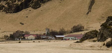 Typical Icelandic landscape with houses against mountains in small village, Western Iceland