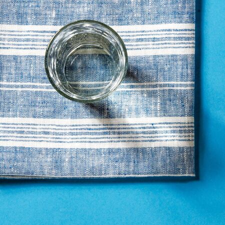 Glass beaker from which padajet sharp shadow, stands on a white background. Empty space for textの写真素材