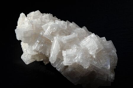A huge white textured crystal of wild sea salt on a black background. Close-upの写真素材
