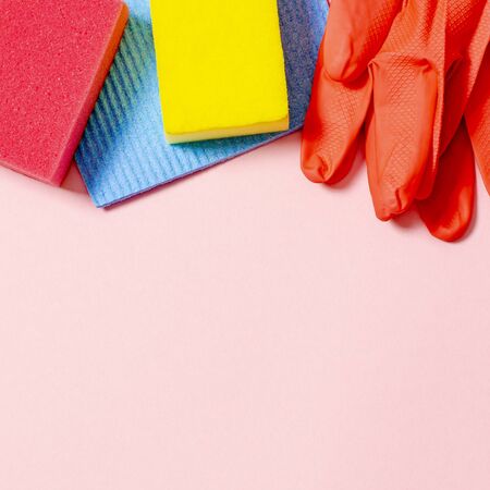 Colorful cleaning set for different surfaces in kitchen, bathroom and other rooms. Empty place for text or logo on green background. Cleaning service concept. Top viewの写真素材